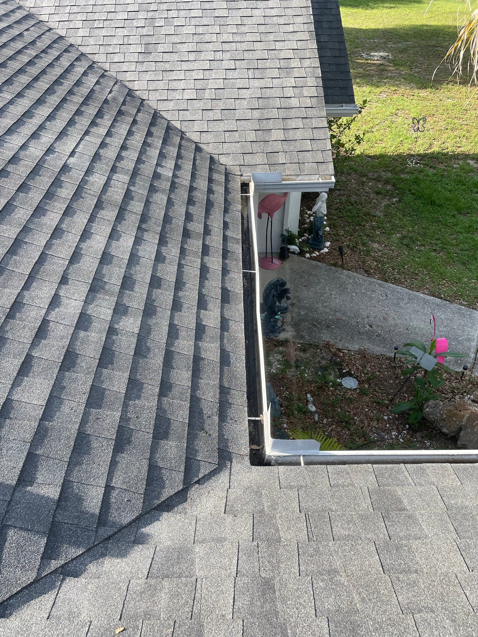 Clean gutters along roof valley with garden decorations below in Port Charlotte