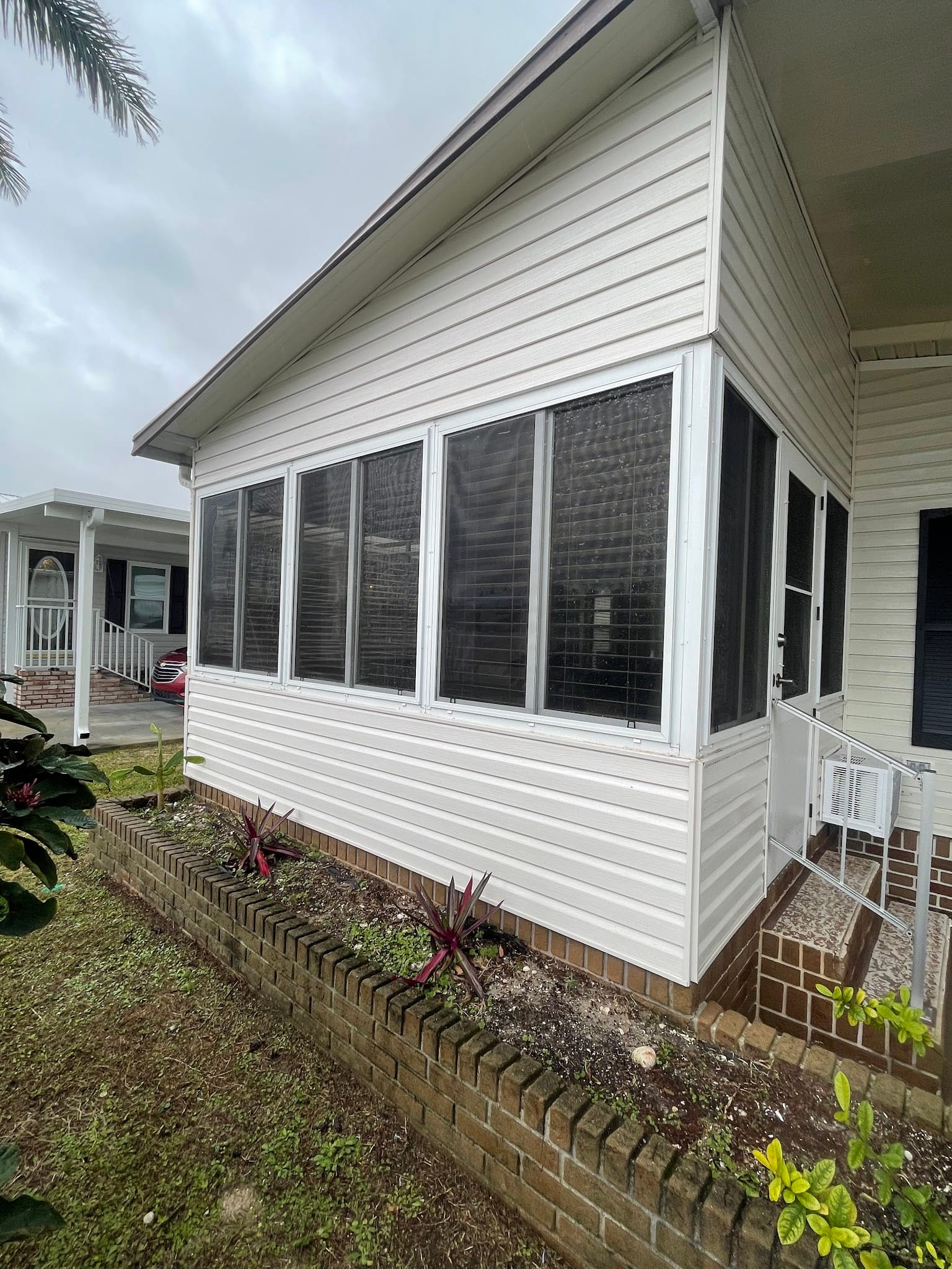 White vinyl enclosed sunroom with gutters on home in Port Charlotte