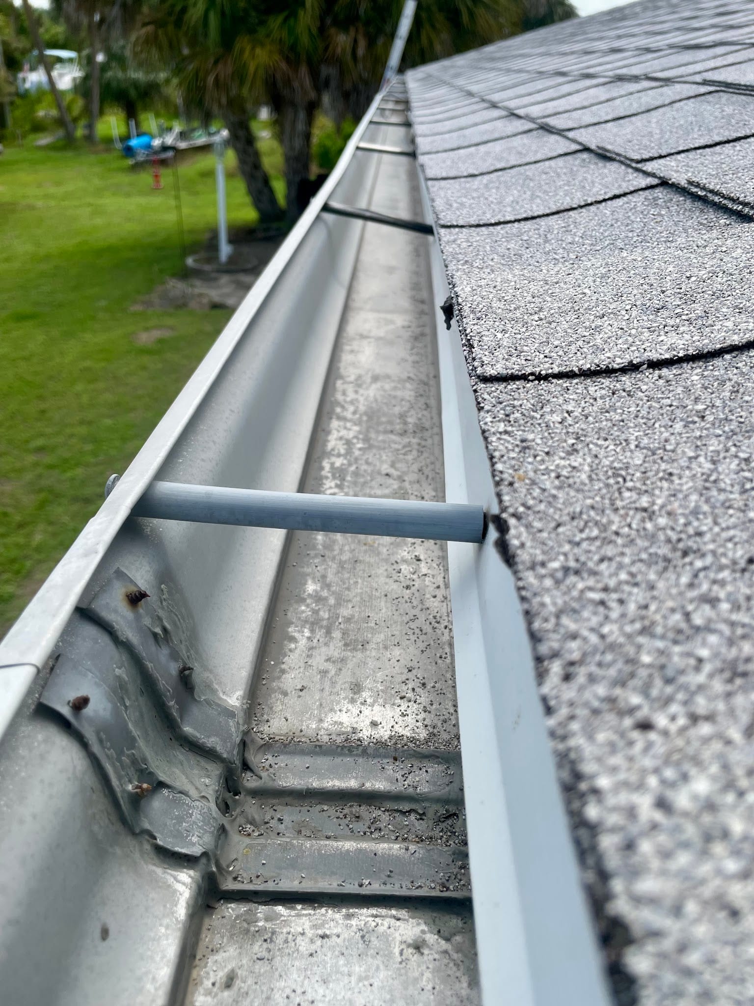Clean aluminum rain gutter along asphalt shingle roof in Port Charlotte