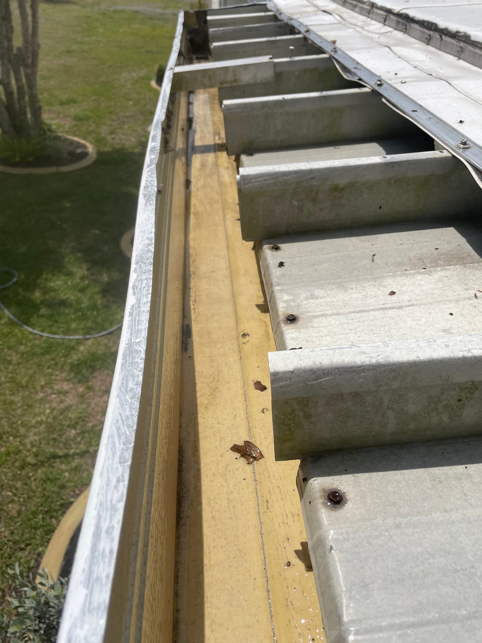 Dirty gutters with debris along metal roof edge in Port Charlotte